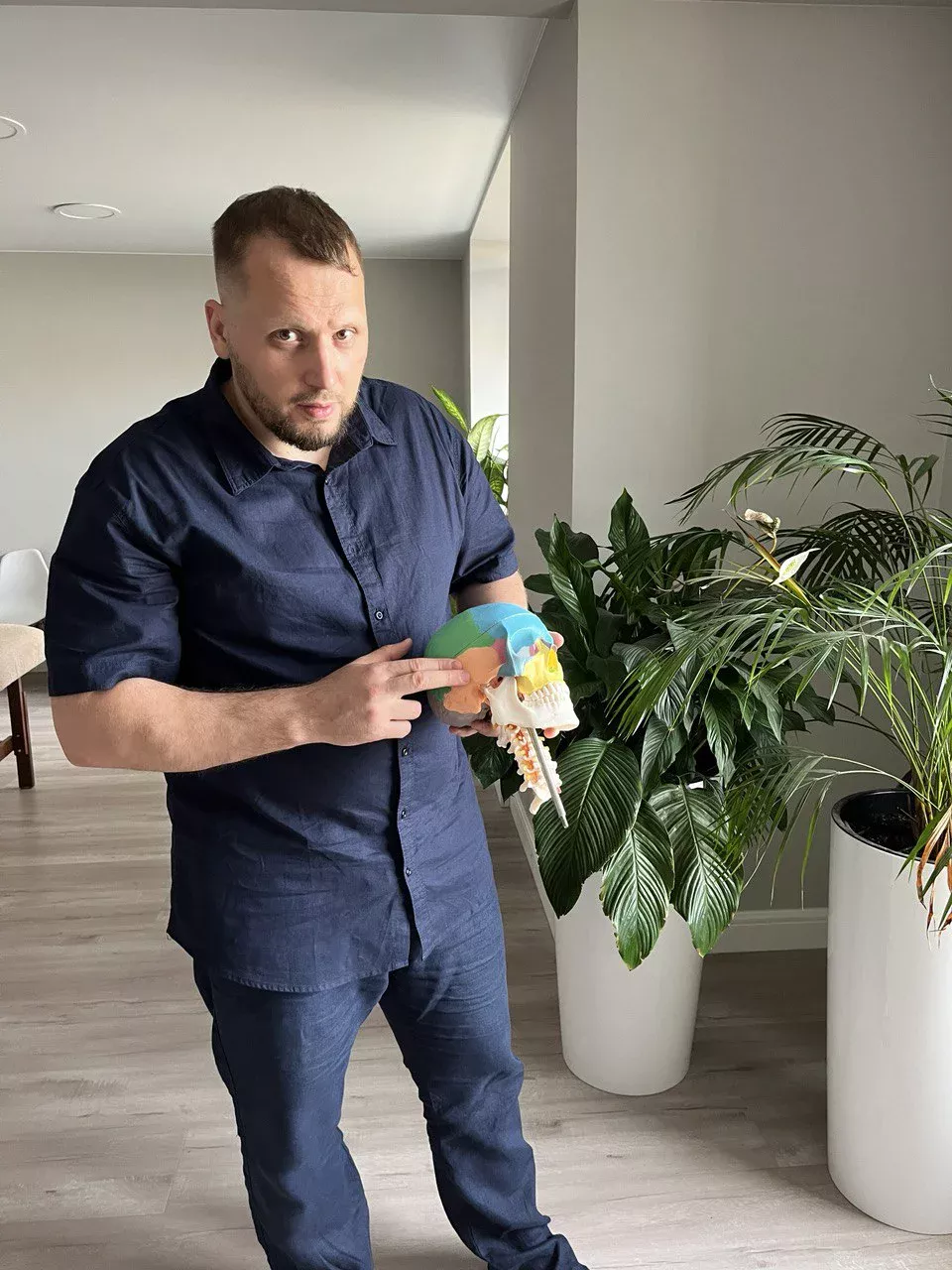 Денис Рынков в кабинете объясняет работу плечевого сустава